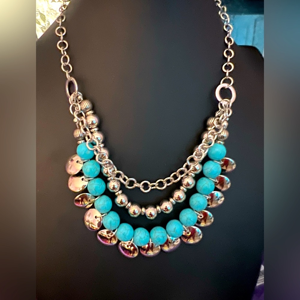 Silver chain with Blue Crackle Stone and several silver circular disks.